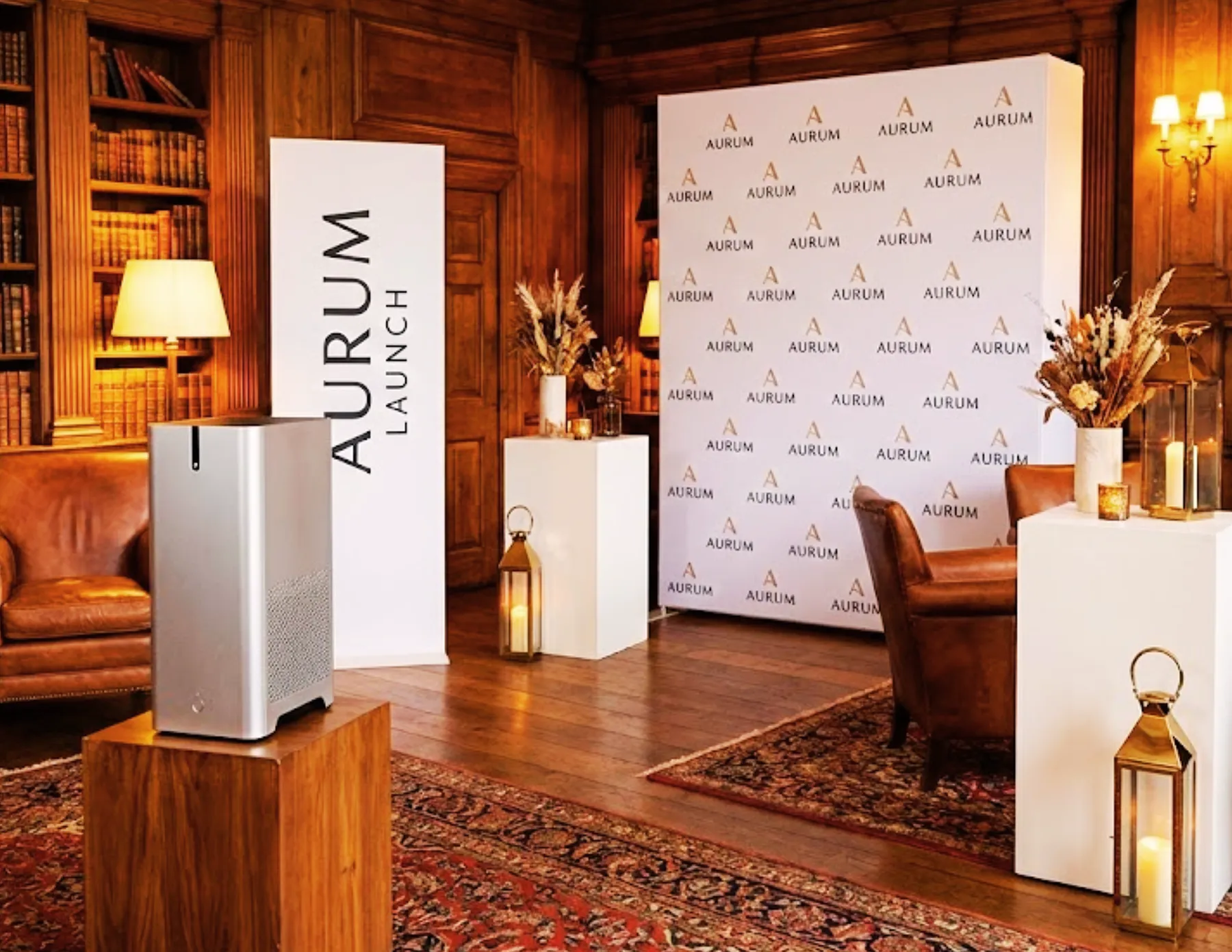 Luxury brand launch event setup with custom Aurum backdrop, lounge seating, branded signage, and elegant decor in a private venue