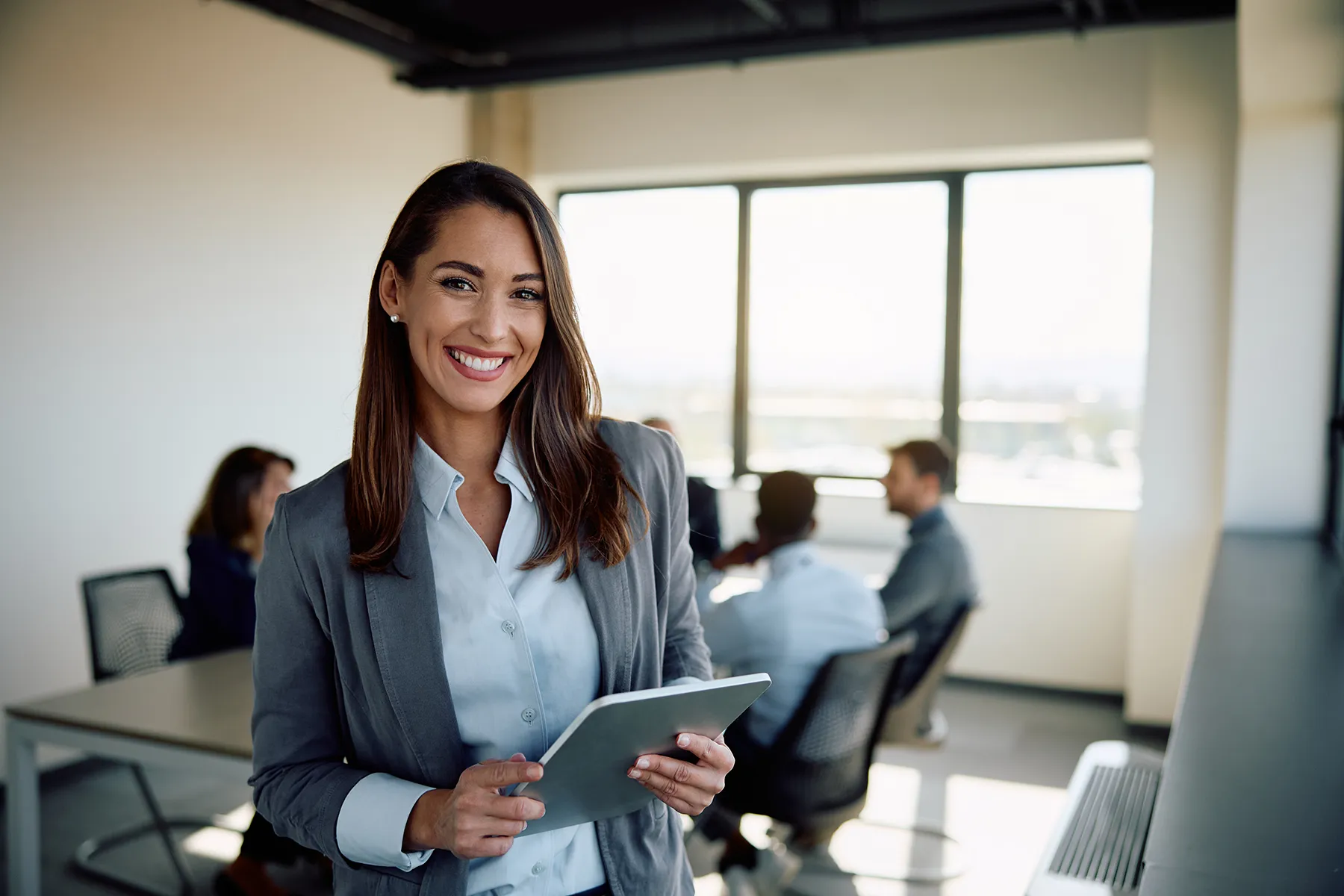 Happy businesswoman with touchpad in the office looking at camera. Happy businesswoman with touchpad in the office looking at camera.