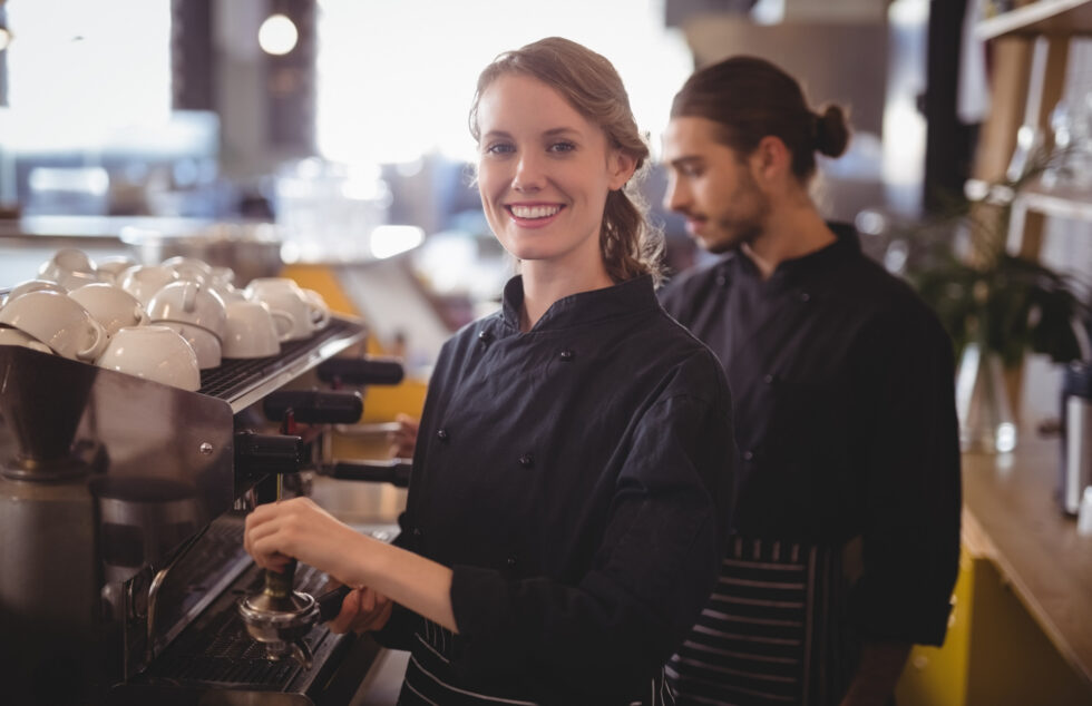 Professional baristas preparing coffee at a restaurant staffed by HMG+ Outsourced team
