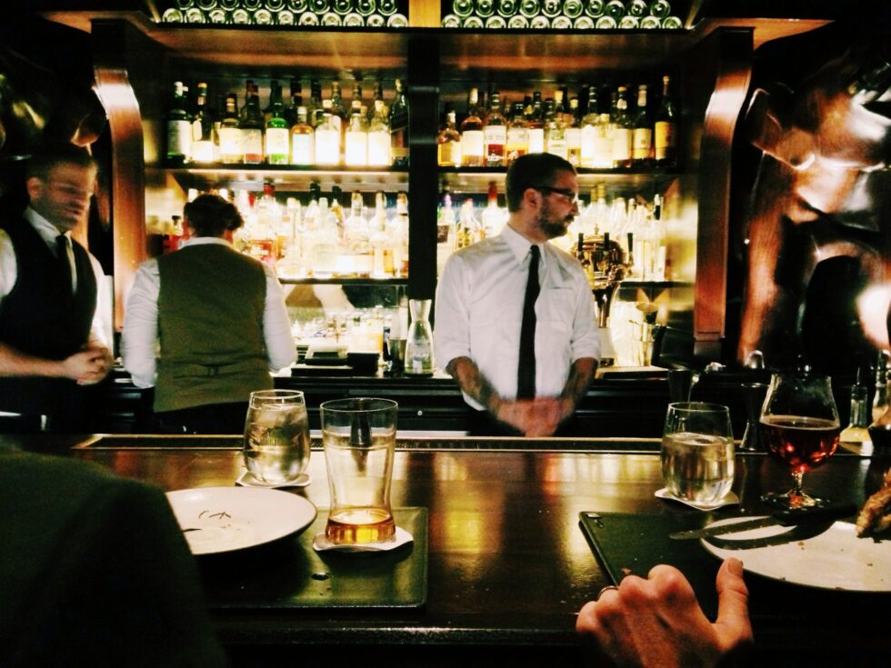 Professional bartenders and restaurant staff serving guests at an upscale bar for a corporate event in New York