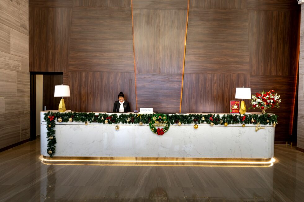 Professional hotel front desk staff member at a luxury hotel reception decorated for the holidays in New York or Chicago