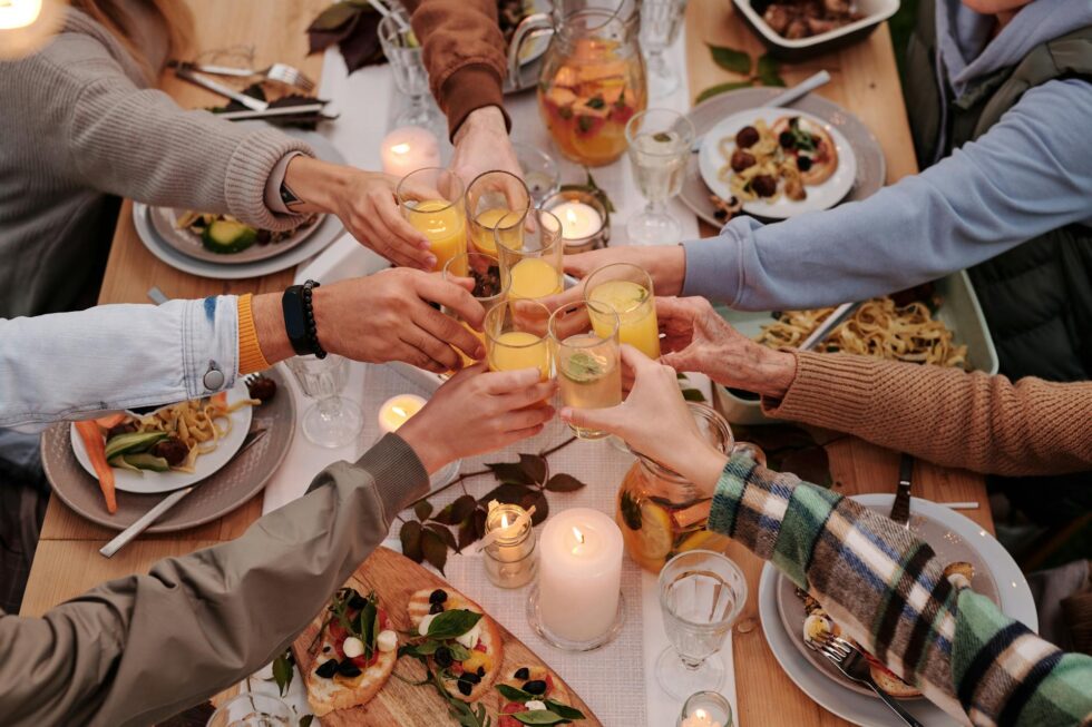 Group of guests raising glasses in a toast over a candlelit dinner table at a professionally catered private event in New York