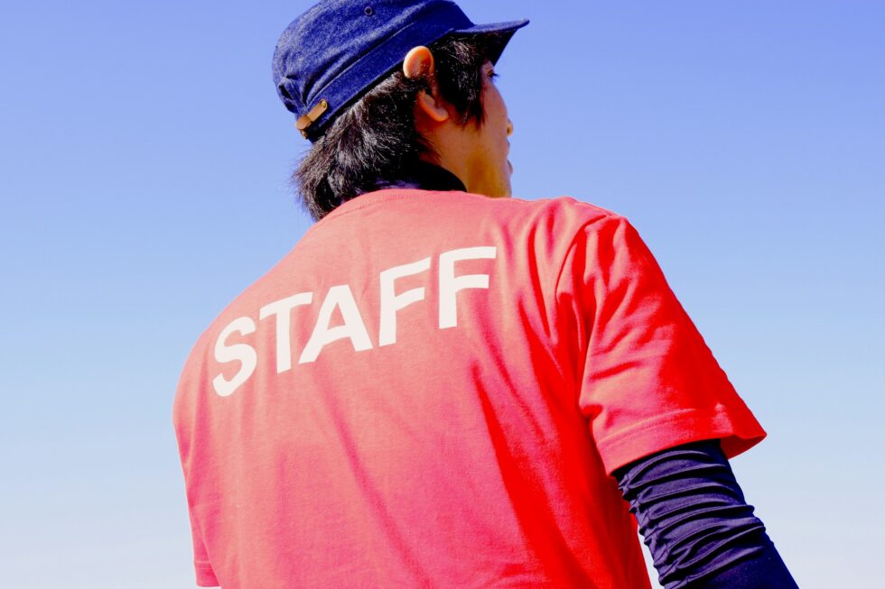 Professional event staff member wearing a red staff shirt ready to manage guests at a large-scale event in New York