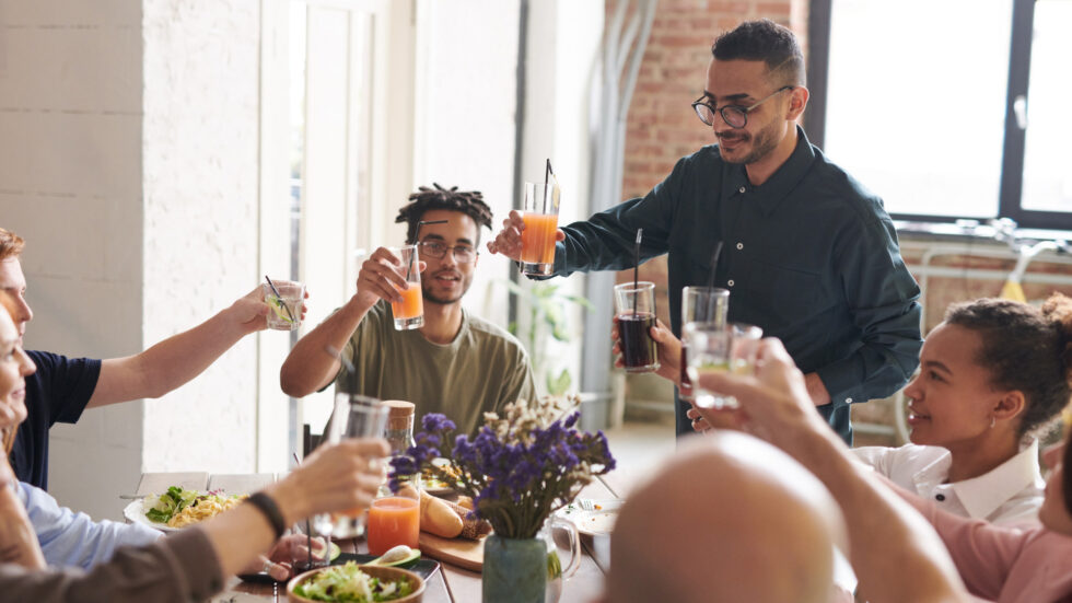 A group of friends raising their glasses to toast at a daytime lunch