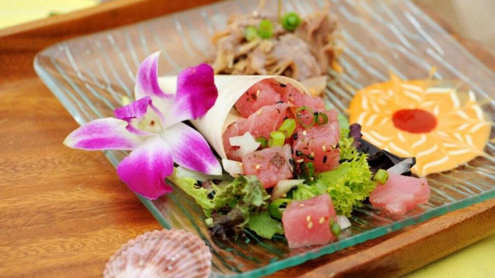 Elegantly plated ahi tuna dish with orchid garnish and mixed greens served at an upscale catered private event or fine dining venue