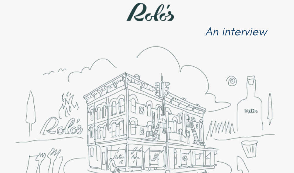 A whimsical hand-drawn illustration of a multi-story corner building labeled 'Rolo's,' surrounded by doodle-style elements including trees, flames, a water bottle, and cutlery, with the text 'Rolo's — An interview' at the top on a light background.